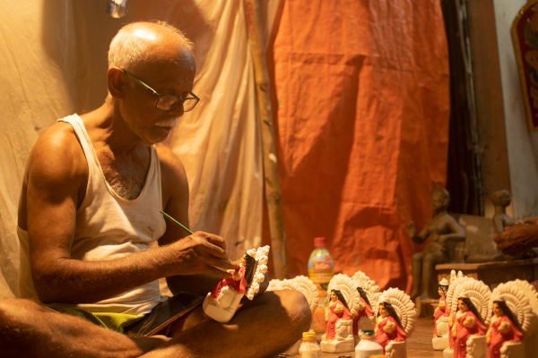 An artist is giving his touch to the idols in Kumartuli workshop.